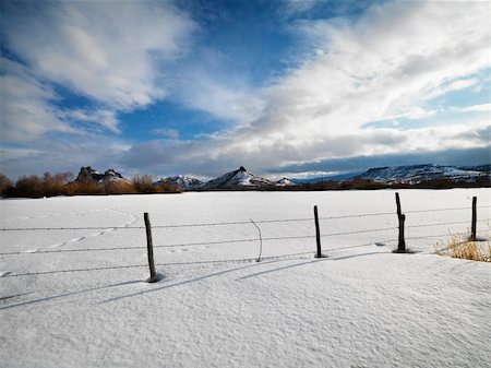 footprint winter landscape mountain - Barbed wire fence with snow covered ground and mountains in background. Stock Photo - Budget Royalty-Free & Subscription, Code: 400-03920941