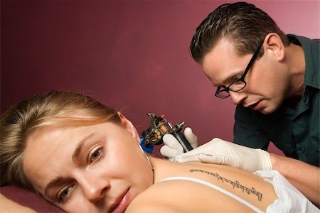 simsearch:400-03921000,k - Caucasian male tattoo artist tattooing Caucasian woman. Stockbilder - Microstock & Abonnement, Bildnummer: 400-03920999