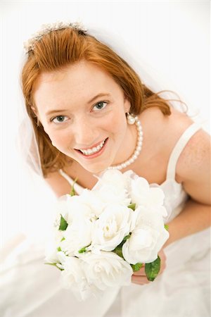 simsearch:400-04950359,k - Portrait of a Caucasian bride holding bouquet looking up towards viewer. Stock Photo - Budget Royalty-Free & Subscription, Code: 400-03921440