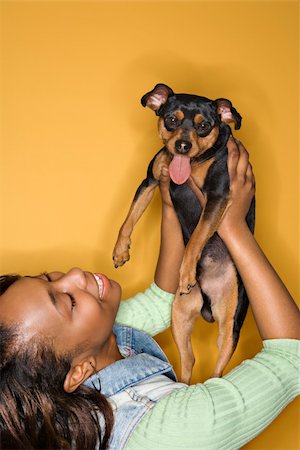 simsearch:400-04446187,k - African American young adult female holding Miniature Pinscher dog. Photographie de stock - Aubaine LD & Abonnement, Code: 400-03921797