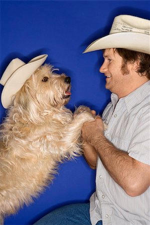 Fluffy brown dog and male Caucasian young adult wearing cowboy hats. Stock Photo - Budget Royalty-Free & Subscription, Code: 400-03921792