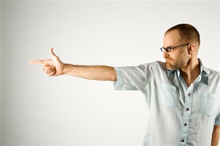 simsearch:400-03926822,k - Portrait of Caucasian man holding hand out like a gun standing against white background. Stock Photo - Budget Royalty-Free & Subscription, Code: 400-03921912