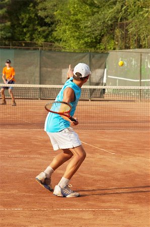 boys playing tennis on the open court Stock Photo - Budget Royalty-Free & Subscription, Code: 400-03922336