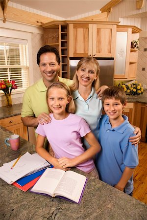 simsearch:400-03923192,k - Caucasian family of four standing in kitchen posing with homework on counter. Foto de stock - Super Valor sin royalties y Suscripción, Código: 400-03923381