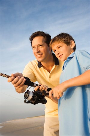 simsearch:400-04953081,k - Caucasian mid-adult man shore fishing on beach with pre-teen boy Foto de stock - Royalty-Free Super Valor e Assinatura, Número: 400-03923413