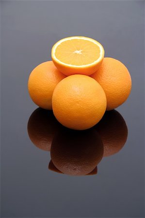 simsearch:859-06470137,k - fresh oranges on reflective background, one is cut in half Stock Photo - Budget Royalty-Free & Subscription, Code: 400-03934668