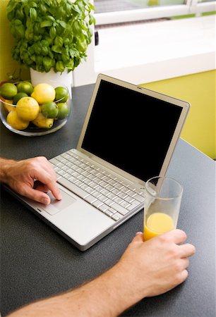 simsearch:400-04443819,k - A computer in the kitchen with a male hand using the touch pad.  The laptop has a completely black screen for easy editing. Stock Photo - Budget Royalty-Free & Subscription, Code: 400-03934686