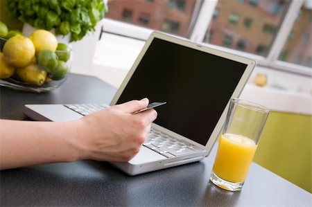 simsearch:400-08116510,k - A young female making an online purchase from her kitchen. Stock Photo - Budget Royalty-Free & Subscription, Code: 400-03934693