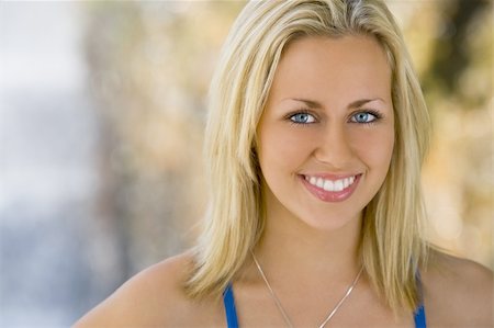 simsearch:400-03920671,k - Portrait of an absolutely gorgeous blond haired blue eyed woman bathed in diffused natural light and smiling in front of an out of focus waterfall Stock Photo - Budget Royalty-Free & Subscription, Code: 400-03935097