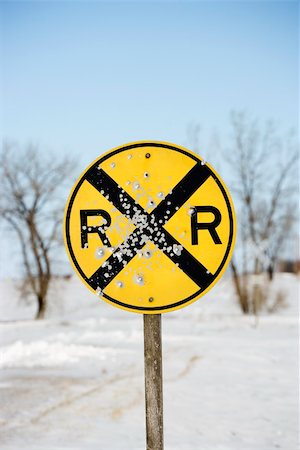 passagem de nível - Railroad crossing sign in snow covered rural landscape. Foto de stock - Royalty-Free Super Valor e Assinatura, Número: 400-03935699