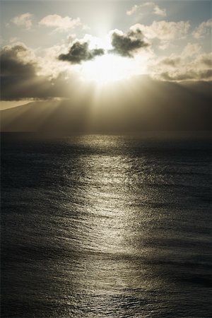 simsearch:400-04006465,k - Pacific ocean and island with sun streaming through clouds. Photographie de stock - Aubaine LD & Abonnement, Code: 400-03935758