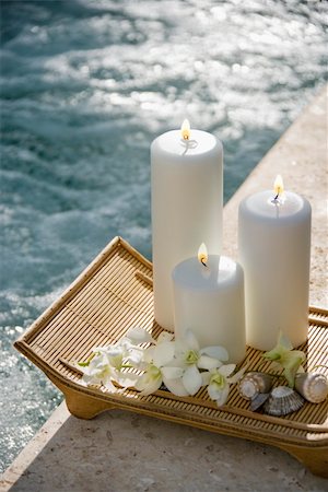 simsearch:400-03925518,k - Lit pillar candles on tray with white orchids beside pool. Stockbilder - Microstock & Abonnement, Bildnummer: 400-03937616