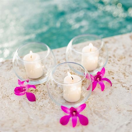 simsearch:400-03925518,k - Three lit candles in glass bowls with purple orchids next to pool. Stockbilder - Microstock & Abonnement, Bildnummer: 400-03937624