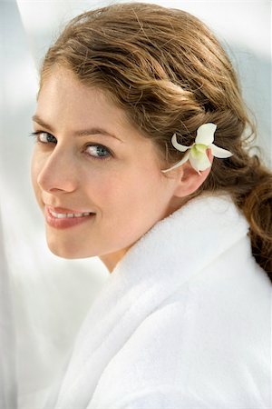 Pretty Caucasian mid-adult woman wearing white terry robe with white orchid flower in hair. Photographie de stock - Aubaine LD & Abonnement, Code: 400-03937622