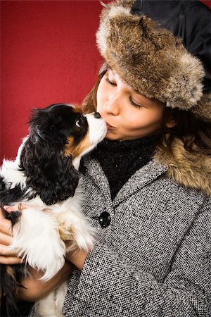 simsearch:400-04951103,k - Young adult Caucasian woman wearing fur hat kissing King Charles Spaniel. Stock Photo - Budget Royalty-Free & Subscription, Code: 400-03937666