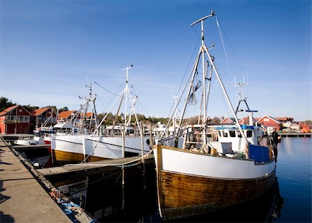 A number of fishing boats sit at dock on a warm summer day. Stock Photo - Budget Royalty-Free & Subscription, Code: 400-03937880