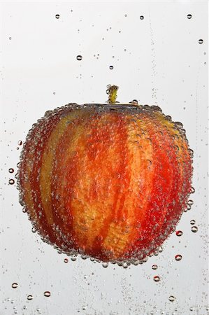 Fresh apple in a clear bubbly liquid on a white background. Foto de stock - Royalty-Free Super Valor e Assinatura, Número: 400-03938684