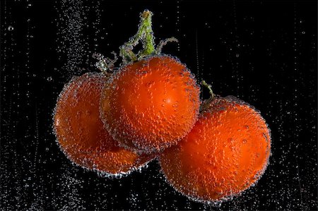 Fresh, clean tomatoes in clear, bubbly liquid. Black background. Photographie de stock - Aubaine LD & Abonnement, Code: 400-03938686