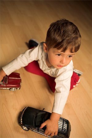 little boy playing indoor with model cars Stock Photo - Budget Royalty-Free & Subscription, Code: 400-03939592