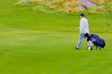 simsearch:400-03975619,k - A golfer with bag, walking along the grass Stock Photo - Budget Royalty-Free & Subscription, Code: 400-03939873