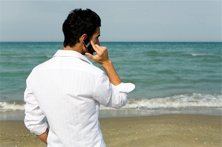 fabthi (artist) - Young man with mobile phone talking and standing in front of the sea Foto de stock - Super Valor sin royalties y Suscripción, Código: 400-03930513