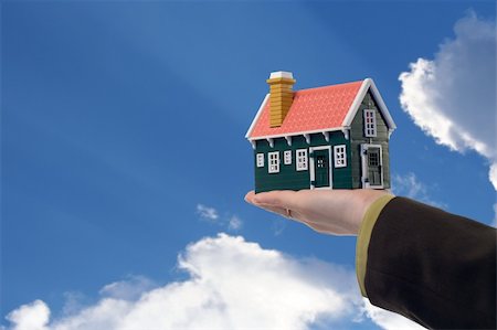 remote (remote location) - Miniature house in woman hand held against blue skies - real estate concept Photographie de stock - Aubaine LD & Abonnement, Code: 400-03933688