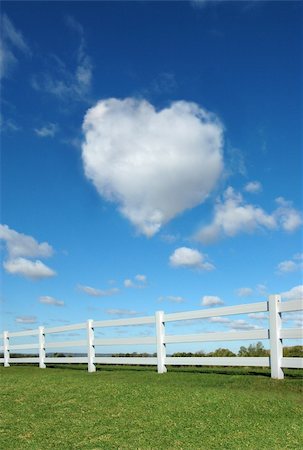 Heart cloud in the sky with white fence in the foreground. Foto de stock - Royalty-Free Super Valor e Assinatura, Número: 400-03944192