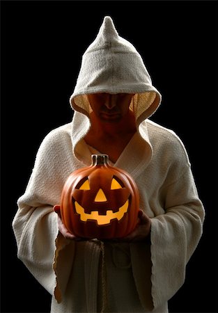 simsearch:400-04236303,k - Hooded man holding a Jack-0-Lantern isolated over a black background. Fotografie stock - Microstock e Abbonamento, Codice: 400-03944211