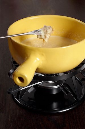 Bread being dipped into the melted cheese in the fondue bowl. Stock Photo - Budget Royalty-Free & Subscription, Code: 400-03944582
