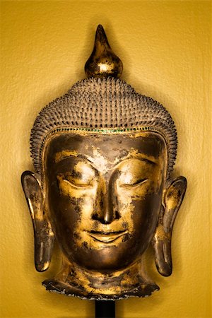 simsearch:400-03944899,k - Bronze Buddha head from Thailand against yellow wall. Stock Photo - Budget Royalty-Free & Subscription, Code: 400-03944894