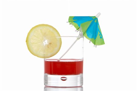 simsearch:649-07065045,k - A glass of red juice with a lemon slice and umbrella, reflected on white background Photographie de stock - Aubaine LD & Abonnement, Code: 400-03945447