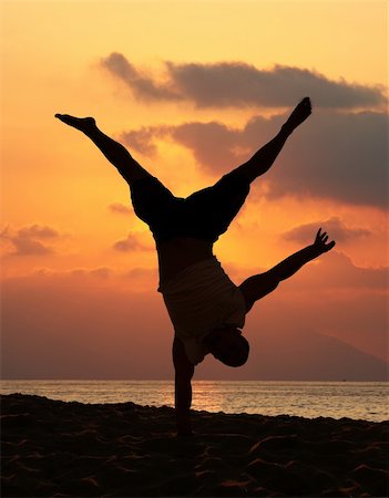 Young man is doing an amazing handstand at sunset Stock Photo - Budget Royalty-Free & Subscription, Code: 400-03945589