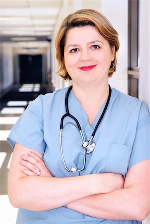 simsearch:6109-06006507,k - Portrait of a smiling nurse in standing in a hospital corridor Fotografie stock - Microstock e Abbonamento, Codice: 400-03946489