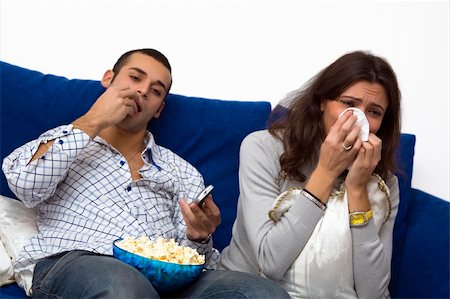 young couple watching a romantic movie on tv. The guy is quite bored.... Stock Photo - Budget Royalty-Free & Subscription, Code: 400-03947048