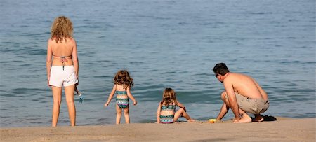 family relaxing with kids in the sun - Family with twin girls on the beach Photographie de stock - Aubaine LD & Abonnement, Code: 400-03947315