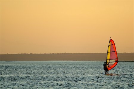 sailor (recreation, male) - Backlit windsurfer at sunset on calm coastal water Stock Photo - Budget Royalty-Free & Subscription, Code: 400-03947403