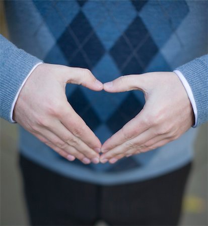close up of single man's hands making a heart shape as he is wearing a blue sweater Stock Photo - Budget Royalty-Free & Subscription, Code: 400-03947836