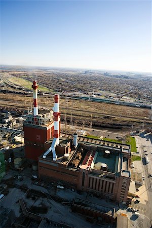 simsearch:400-03948597,k - Aerial view of factory with smokestacks and city in distance. Photographie de stock - Aubaine LD & Abonnement, Code: 400-03948642