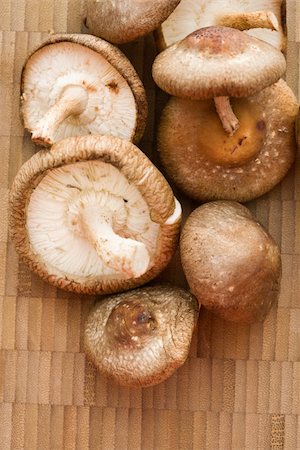 simsearch:632-03898513,k - Pile of shiitake mushrooms on bamboo mat. Foto de stock - Super Valor sin royalties y Suscripción, Código: 400-03949224
