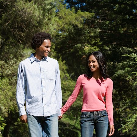 simsearch:400-03943979,k - Smiling couple holding hands walking and talking in park. Foto de stock - Super Valor sin royalties y Suscripción, Código: 400-03949247