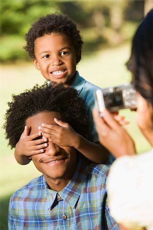 Woman taking digital photo of husband and son in park. Photographie de stock - Aubaine LD & Abonnement, Code: 400-03949282