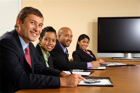 Businesspeople sitting at conference table smiling with flat screen display in background. Stock Photo - Budget Royalty-Free & Subscription, Code: 400-03949344