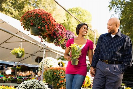 Happy smiling couple picking out flowers at outdoor plant market walking and holding hands. Stock Photo - Budget Royalty-Free & Subscription, Code: 400-03949427