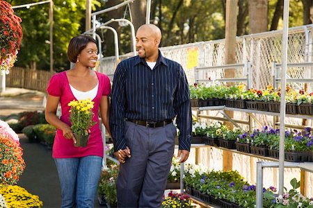 Happy smiling couple picking out flowers at outdoor plant market walking and holding hands. Stock Photo - Budget Royalty-Free & Subscription, Code: 400-03949422