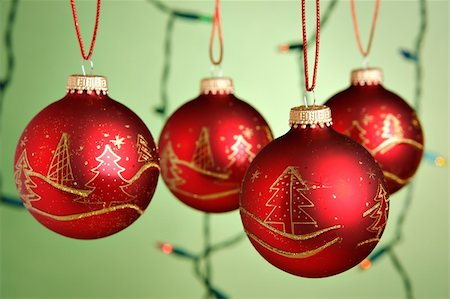round ornament hanging of a tree - Christmas baubles hanging over green background Stock Photo - Budget Royalty-Free & Subscription, Code: 400-03949619
