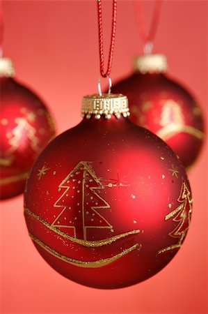 round ornament hanging of a tree - Three christmas baubles hanging over red background Stock Photo - Budget Royalty-Free & Subscription, Code: 400-03949621