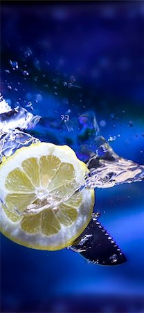 simsearch:6118-07351735,k - lemon splash in transparent glass over blue background Stock Photo - Budget Royalty-Free & Subscription, Code: 400-03940328