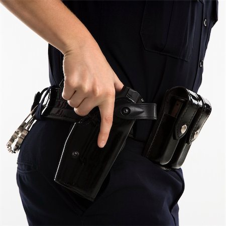 Close up side view of mid adult female Caucasian law enforcement officer hand on gun in holster. Stock Photo - Budget Royalty-Free & Subscription, Code: 400-03940744