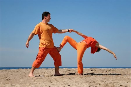 simsearch:400-06751687,k - Couple in orange clothes having fun on the beach Stock Photo - Budget Royalty-Free & Subscription, Code: 400-03940780