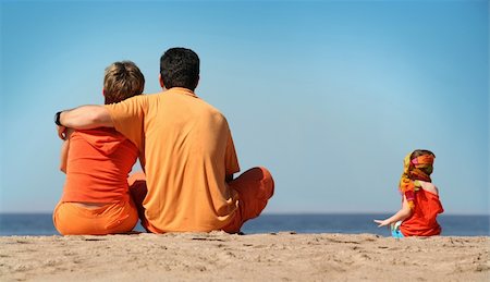 family relaxing with kids in the sun - Family in orange clothes on the beach Photographie de stock - Aubaine LD & Abonnement, Code: 400-03940781